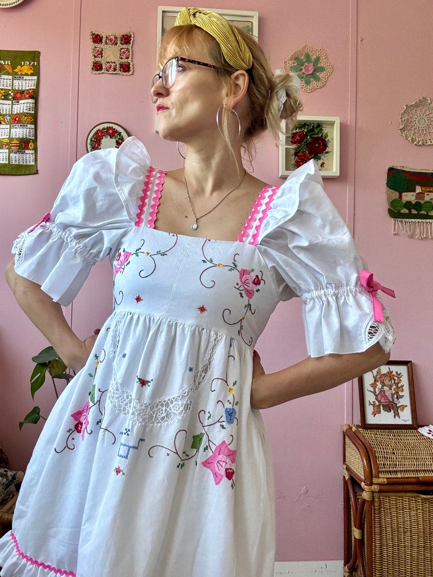 White dress with floral appliqués and pink ric rac