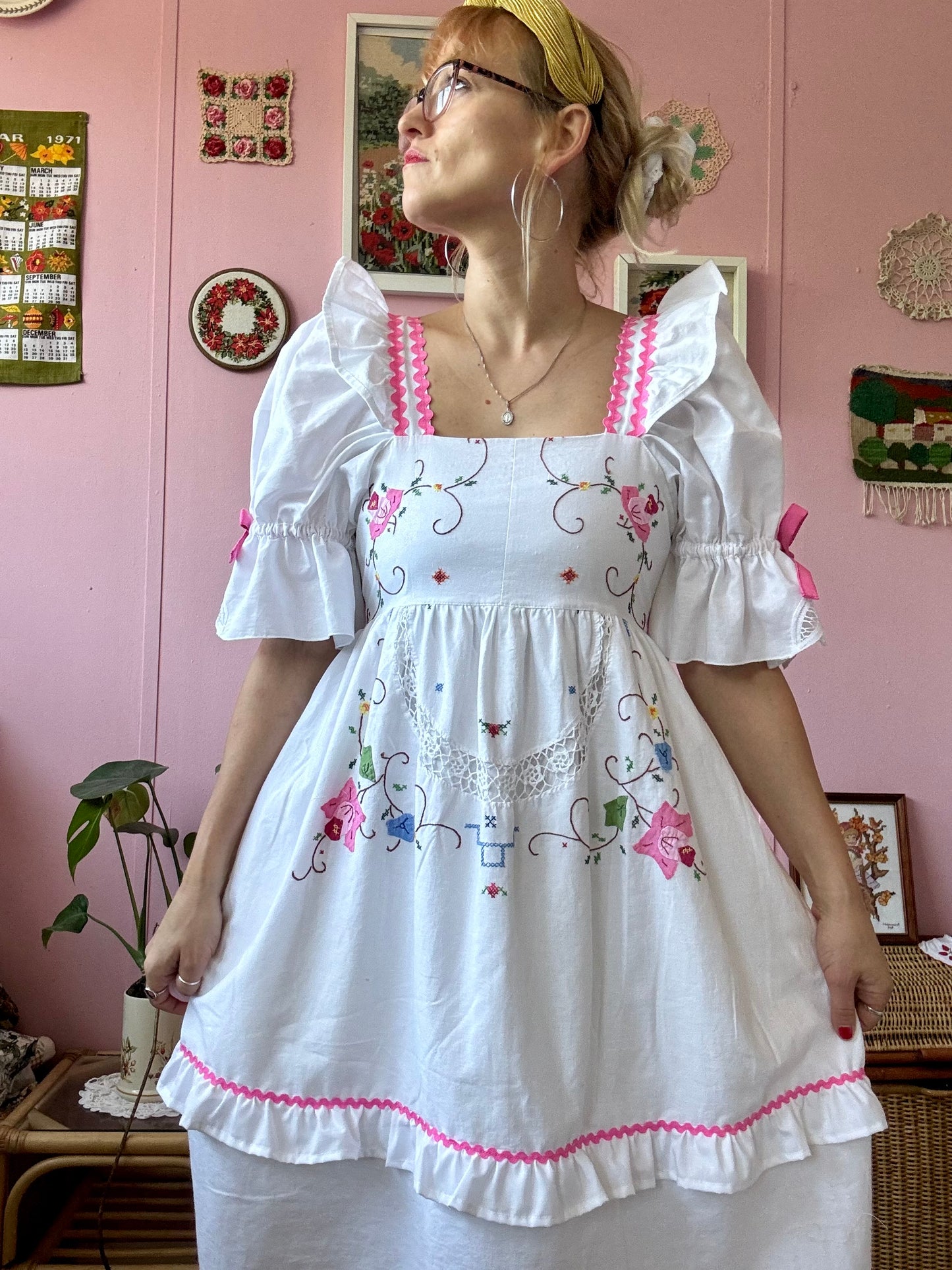 White dress with floral appliqués and pink ric rac