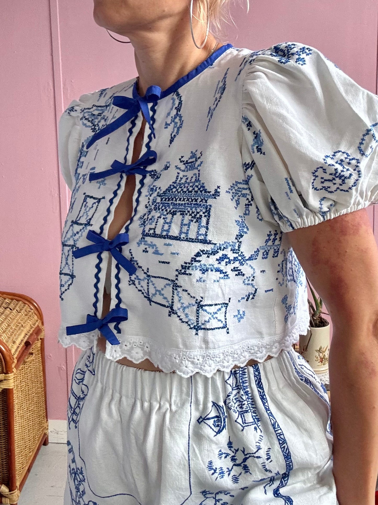 Short blouse with blue embroidery and blue bows