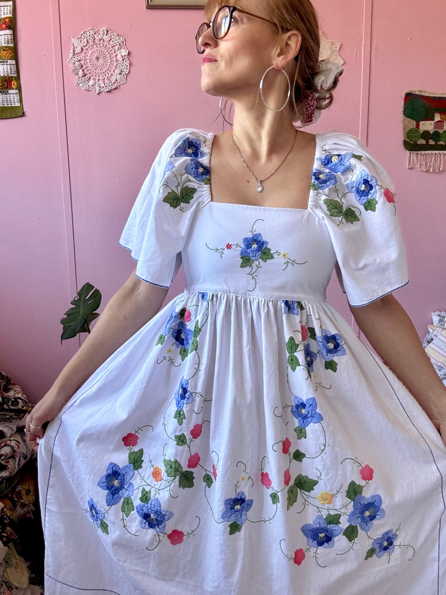 White maxi dress with blue floral appliqués