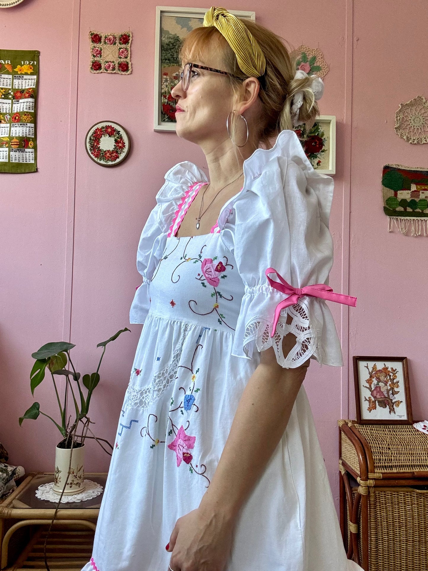 White dress with floral appliqués and pink ric rac