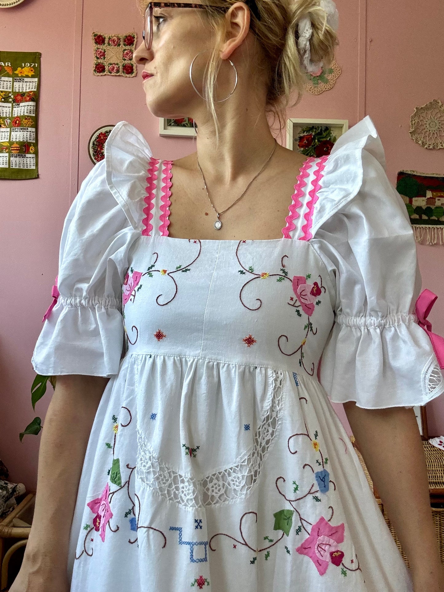 White dress with floral appliqués and pink ric rac