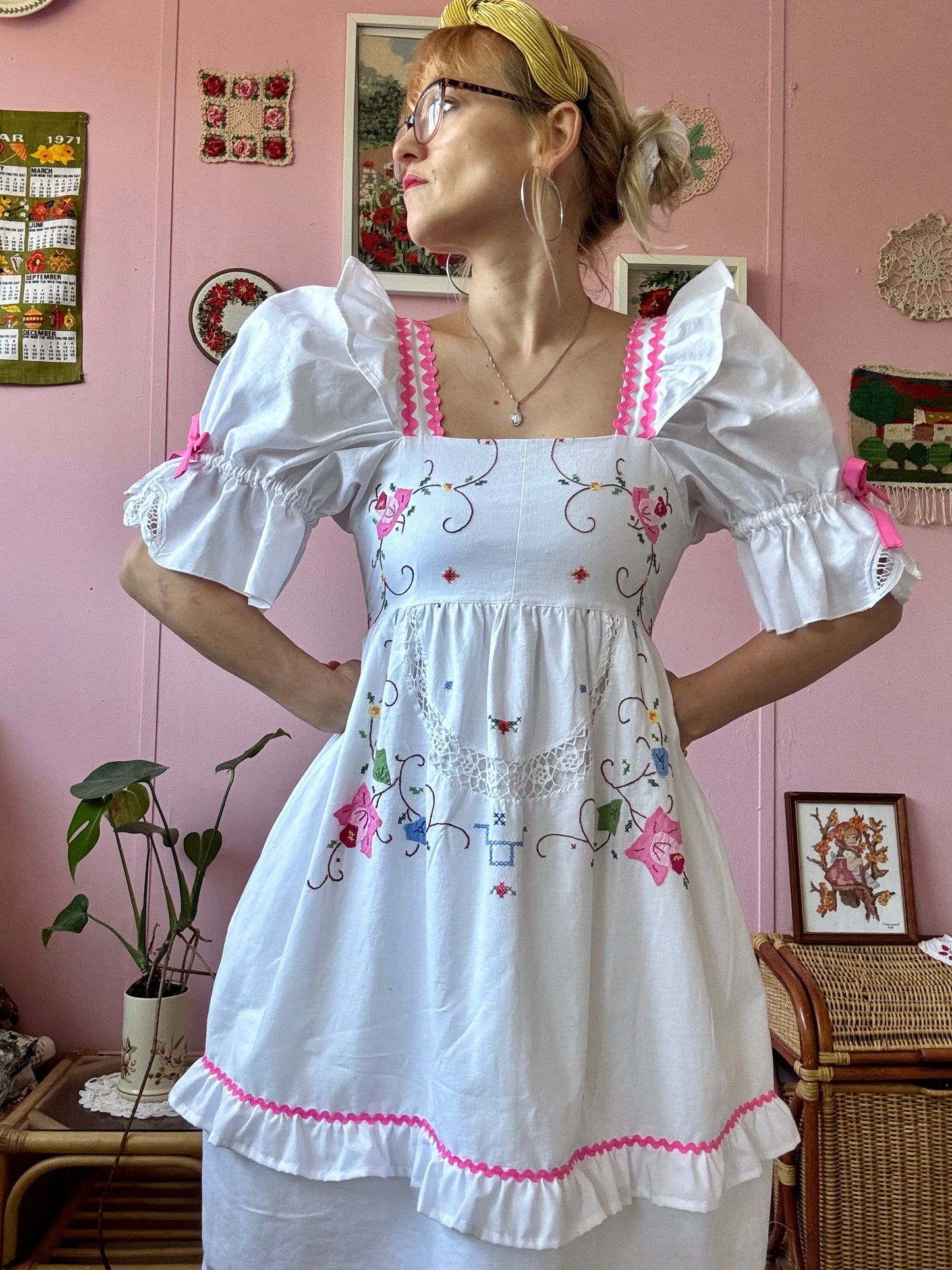 White dress with floral appliqués and pink ric rac