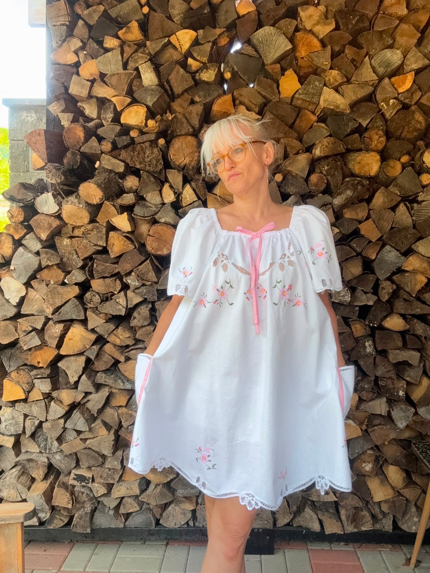 White dress with pink bow and pink cross stitching flowers