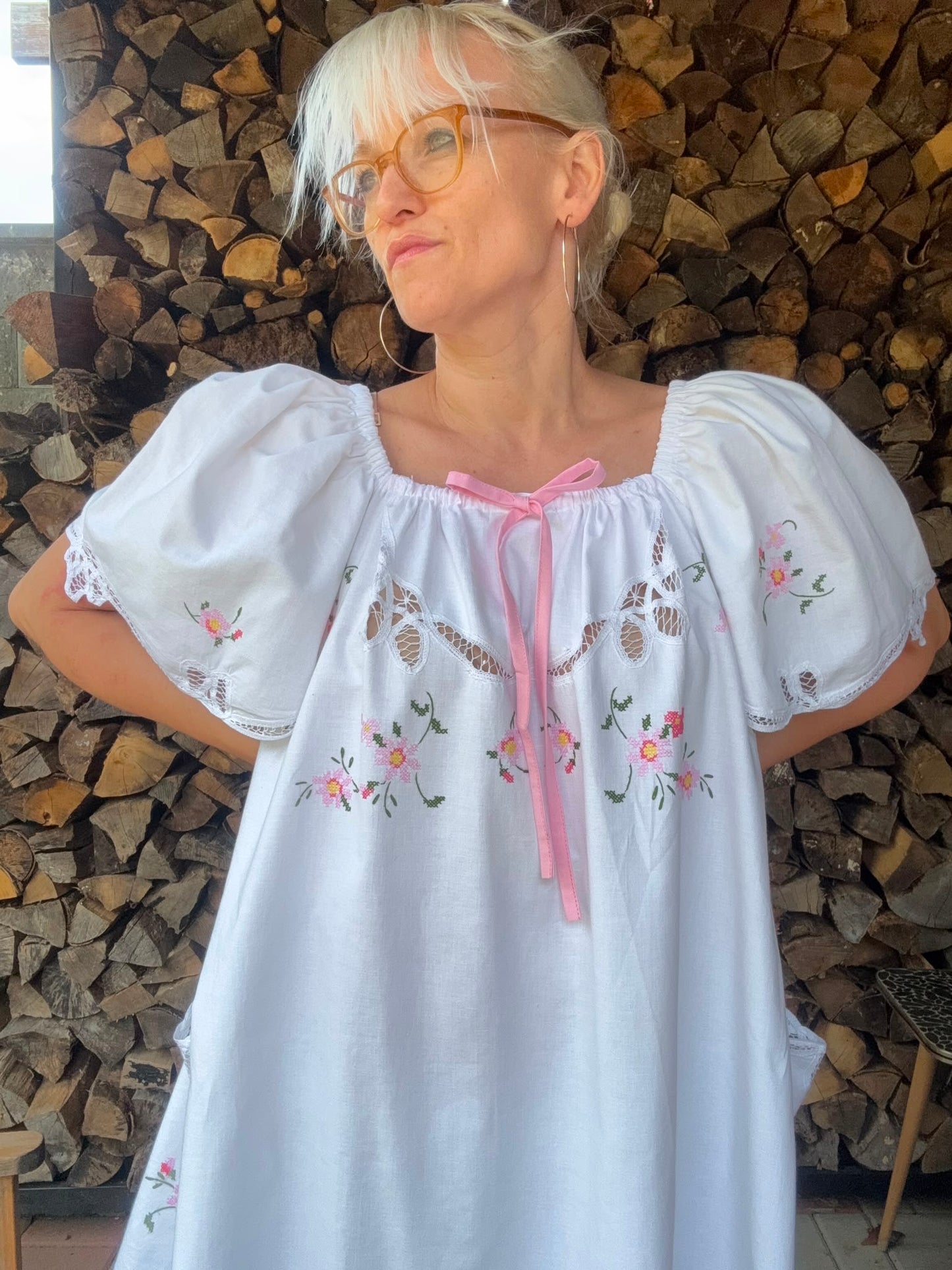 White dress with pink bow and pink cross stitching flowers