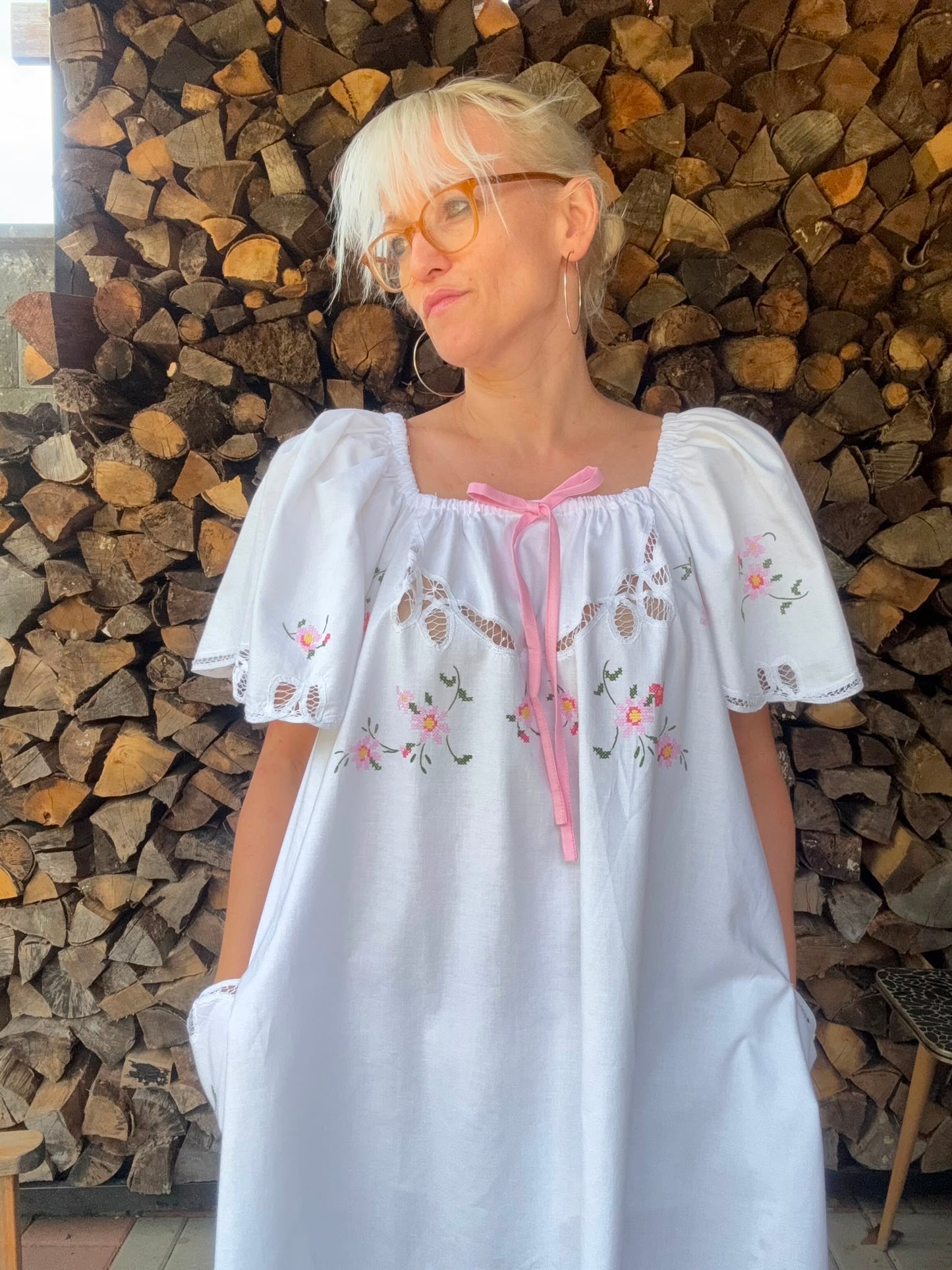 White dress with pink bow and pink cross stitching flowers