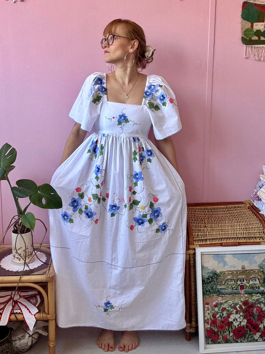 White maxi dress with blue floral appliqués