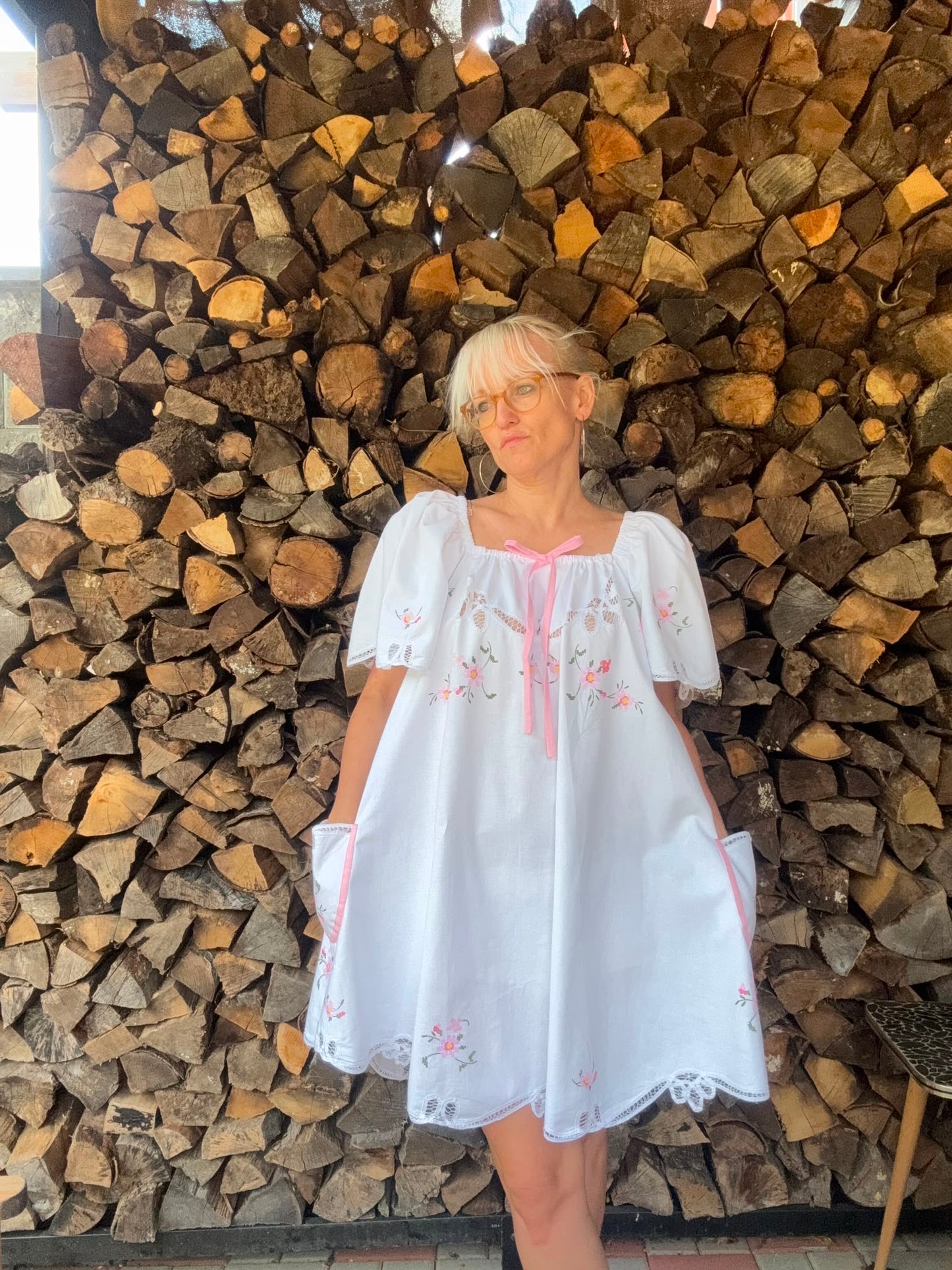 White dress with pink bow and pink cross stitching flowers