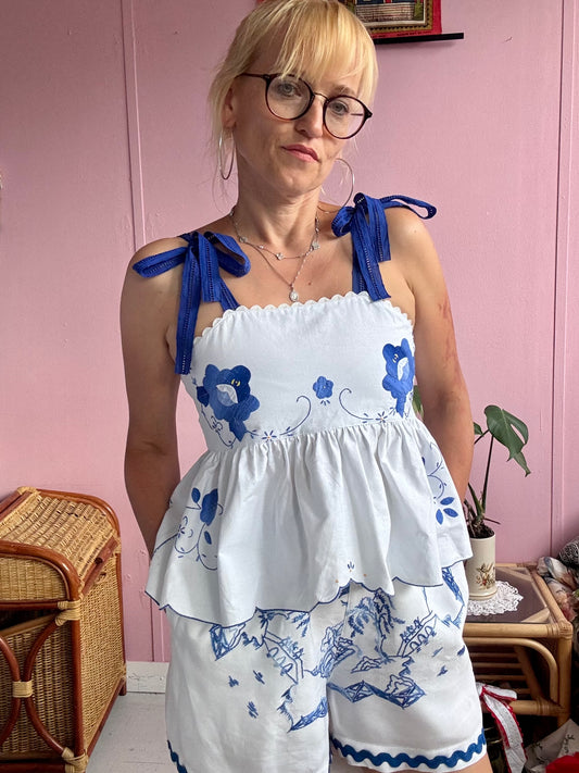 White top with blue floral appliqués