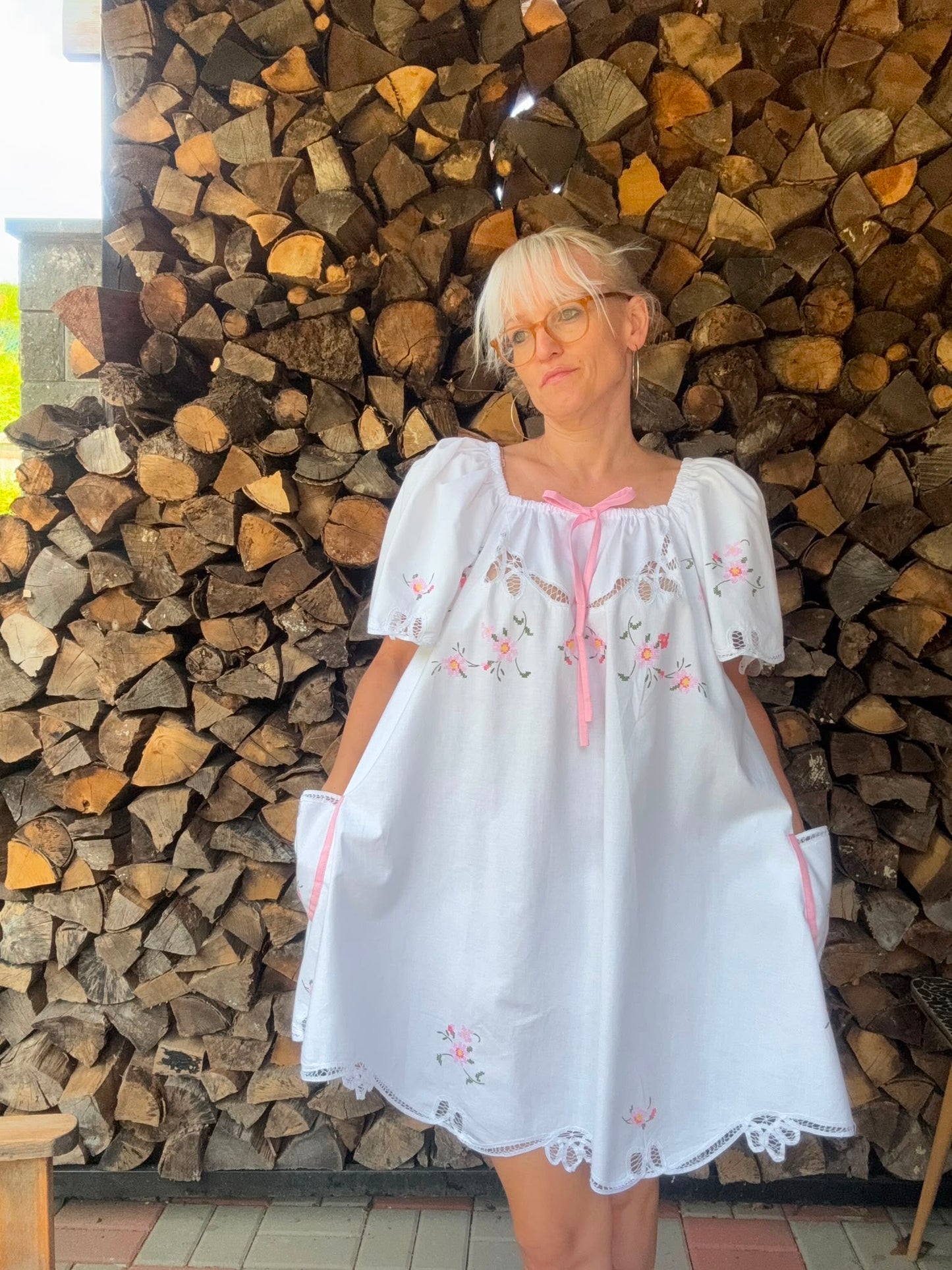 White dress with pink bow and pink cross stitching flowers
